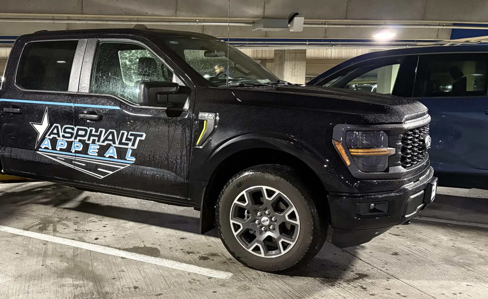Black Asphalt Appeal pickup truck with the blue star logo on the door